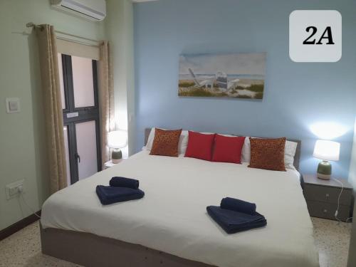 圣保罗湾城Seabreeze Guest Rooms的一间卧室配有一张大床,上面有两条蓝色的毛巾