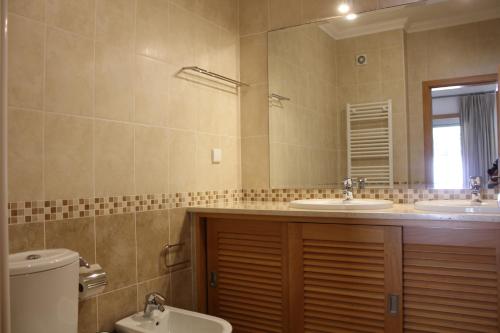 奥比多斯Confortavel T2的浴室设有2个水槽、卫生间和镜子。