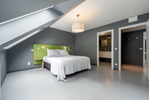 布鲁塞尔Smartflats Design - Postiers的一间卧室配有一张白色床和绿色床头板