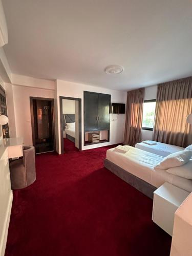 丹吉尔Crystal boulevard的酒店客房,设有两张床,铺有红地毯。