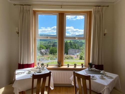 皮特洛赫里贝因布雷凯旅馆的一间带两张桌子和大窗户的用餐室