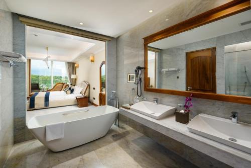乌纳瓦图纳Araliya Beach Resort & Spa Unawatuna的一间带两个盥洗盆和大镜子的浴室