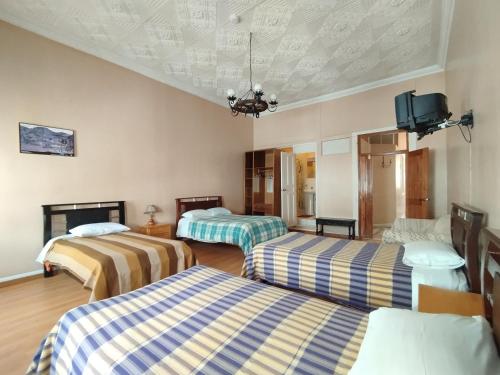 拉塔昆加Hotel Rosim Cotopaxi的带三张床和电视的客房