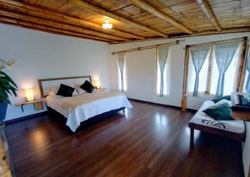 菲兰迪亚Casa Laureles的一间卧室配有一张床、一张沙发和窗户。