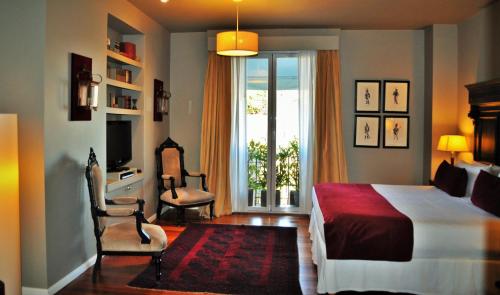 布宜诺斯艾利斯Legado Mitico Buenos Aires的一间卧室配有一张床、两把椅子和一个窗户