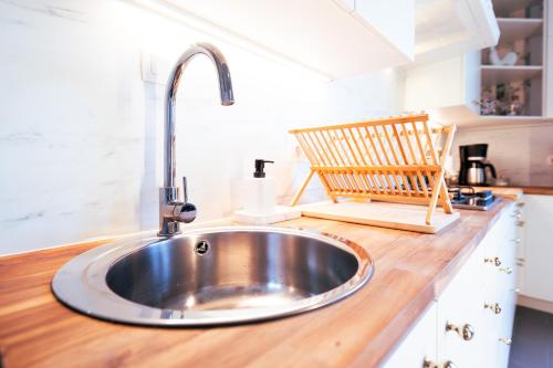 蒙斯Lets Relax - Coté jardin的厨房里的一个水槽,配有木制台面