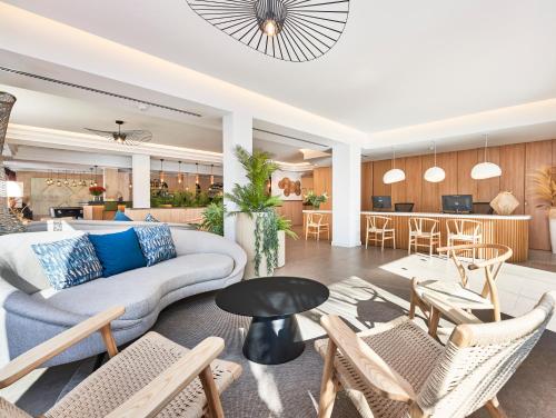 卡拉纳雅达Flacalco Hotel & Apartments的客厅配有沙发、椅子和桌子