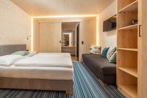 斯拉德明Ferienalm Panorama Apartments的一间卧室配有一张床和一张沙发