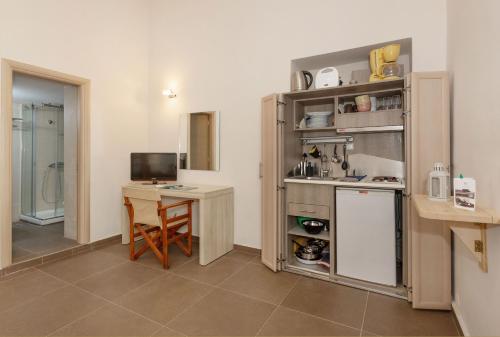 索瓦拉Oinoni's Home - ACHILLES studio的厨房配有桌子和带电脑的书桌