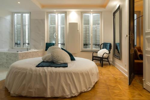 蓬塔穆松Suite Atemporelle - SPA room的一间卧室配有一张床,浴室设有浴缸