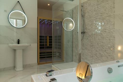 蓬塔穆松Suite Atemporelle - SPA room的带浴缸、水槽和镜子的浴室