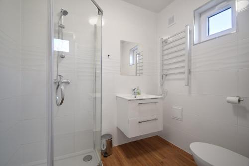 格里兹鲍Westbeach House的带淋浴和盥洗盆的白色浴室