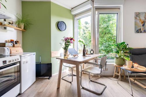 奈梅亨Cozy House - fietsverhuur, eigen keuken en badkamer的厨房配有桌椅和窗户。
