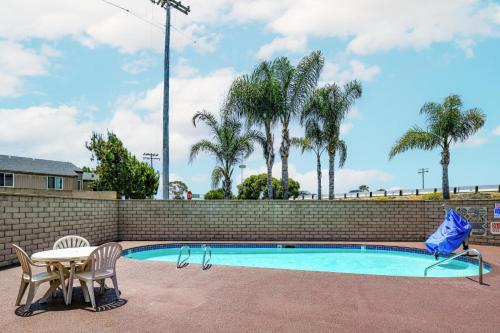 卡尔斯巴德乐高乐园附近海兰酒店的砖墙旁的游泳池,配有桌椅