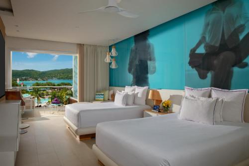 蒙特哥贝绝美蒙特哥湾度假酒店的一间卧室设有两张床和蓝色的墙壁