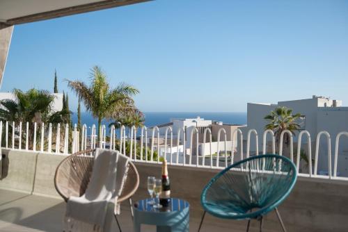 阿德耶KARAT Villa Calypso Costa Adeje的阳台配有两把椅子和一张桌子,设有围栏