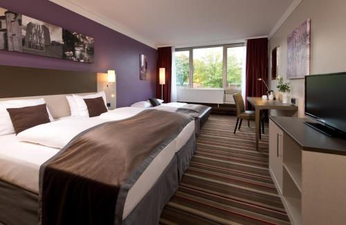 门兴格拉德巴赫门兴格拉德巴赫莱昂纳多酒店的酒店客房设有两张床和电视。