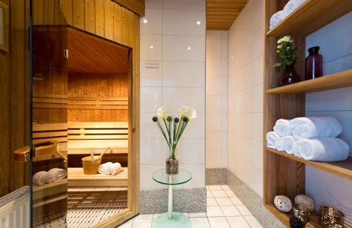 门兴格拉德巴赫门兴格拉德巴赫莱昂纳多酒店的浴室提供毛巾和花瓶,摆放在桌子上