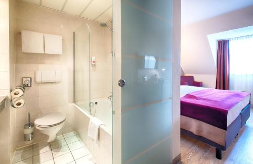 拉登堡曼海姆-拉登堡莱昂纳多酒店的一间带床、卫生间和淋浴的浴室