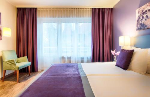 苏黎世苏黎世雷奥纳多精品酒店的一间卧室设有一张大床和一个窗户。