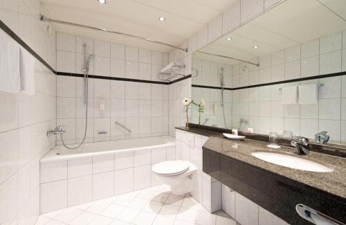 科隆科隆波恩机场莱昂纳多酒店的浴室配有卫生间、盥洗盆和浴缸。