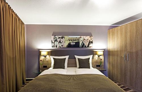 纽伦堡纽伦堡莱昂纳多酒店的一间卧室配有一张大床和两个枕头