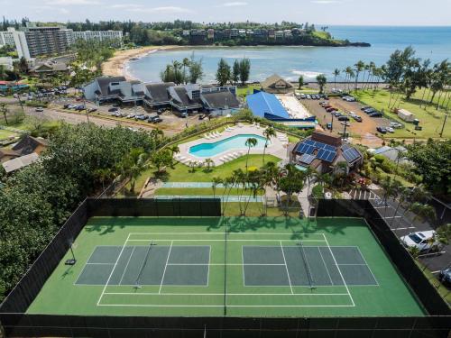 利胡埃Banyan Harbor Resort的享有网球场和海滩的空中景致