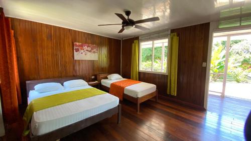 托尔图格罗La Baula Lodge的一间卧室配有两张床和吊扇