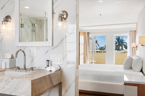 迈阿密海滩海洋酒店 的白色的浴室设有浴缸和水槽。