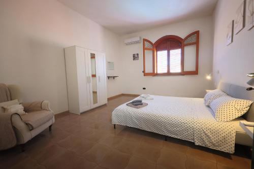 阿沃拉Casa di Sara&Anna的卧室配有床、椅子和窗户。