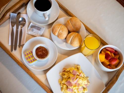 利马布里塔尼亚圣博尔哈酒店的托盘,包括早餐食品和咖啡