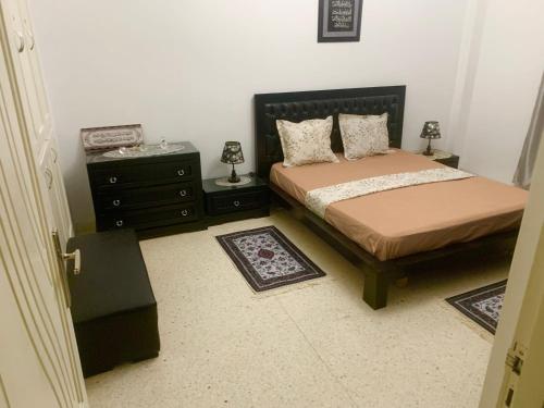 突尼斯Dream Appartement El Aouina的一间卧室配有一张床、梳妆台和一张睡床。