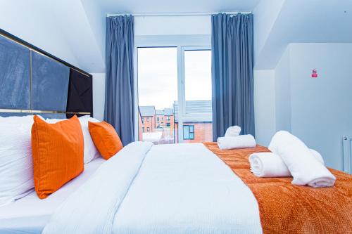 曼彻斯特The Edge - Enjoy a luxury stay的一间卧室配有一张带橙色和白色枕头的大床