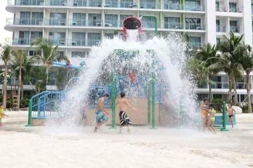 马尼拉Azure Urban Residences的三个孩子在海滩上的喷泉玩耍