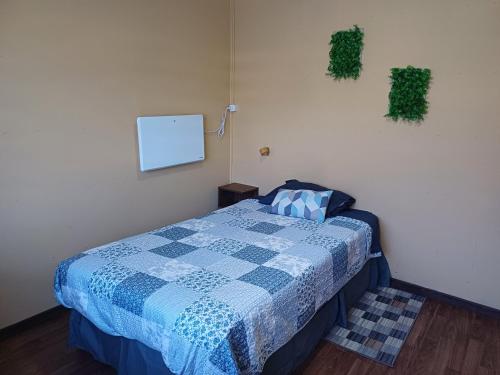 蓬塔阿雷纳斯Casa Celeste的一间卧室配有一张带蓝色和白色被子的床