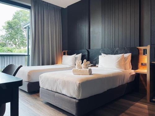 沙敦INN BLOG HOTEL Pakbara的酒店客房设有两张床和窗户。