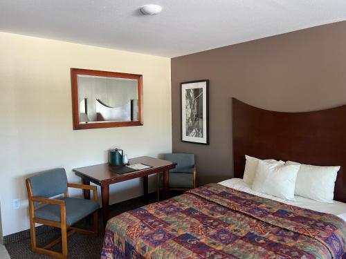 威斯康星戴尔All Star Inn & Suites的酒店客房配有一张床铺、一张桌子和一张书桌。