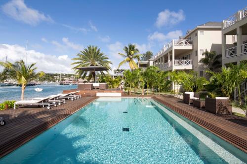 英吉利港安提瓜萨斯普特酒店的一座与度假村相连的建筑旁边的游泳池