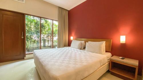 梭罗Lorin Dwangsa Solo Hotel的一间卧室设有一张大床和一个大窗户