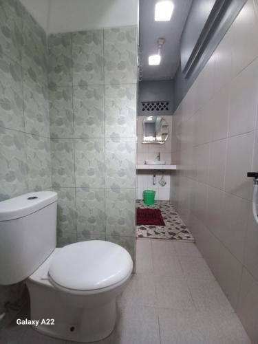 婆罗浮屠ADA Homestay的一间位于客房内的白色卫生间的浴室