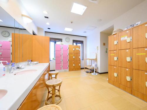TagaRest Inn Taga的大型浴室设有两个盥洗盆和粉红色储物柜。