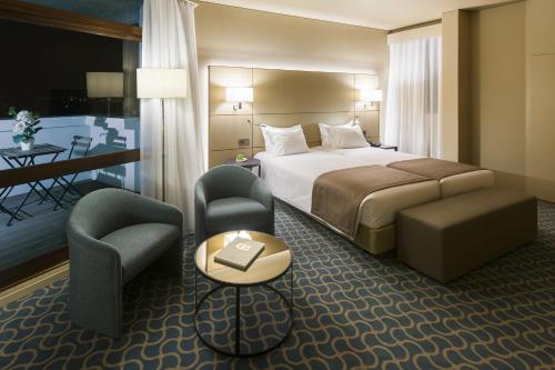 波尔图市中心大教堂恩里克酒店的酒店客房,配有一张床和两把椅子