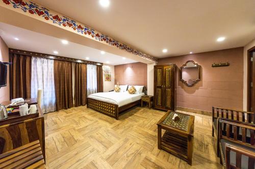焦特布尔Khamma Heritage的一间卧室配有一张床、一张桌子和一台电视。