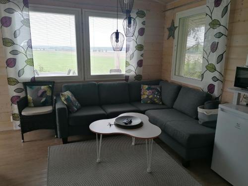 NivalaViihtyisä saunamökki päärakennuksen takana, oma rauha的客厅配有沙发和桌子