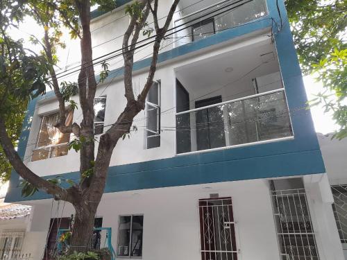 卡塔赫纳Apartaestudio Cartagena 2P的蓝白色的建筑,前面有一棵树