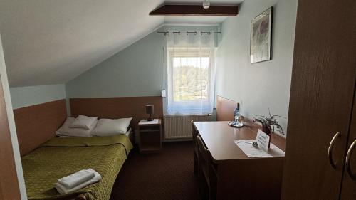 皮拉Motel Orion的客房设有两张床、一张桌子和一个窗户。