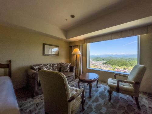 高山阿索西亚塔卡亚谜度假酒店的带沙发和椅子的客厅以及大窗户。