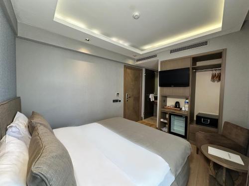 伊斯坦布尔Grand Beyazit Hotel Old City的卧室配有一张白色大床和电视。