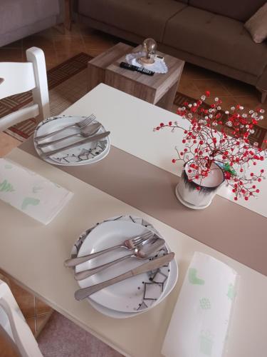 培拉特Vangert Apartment的一张带盘子和鲜花的白色桌子