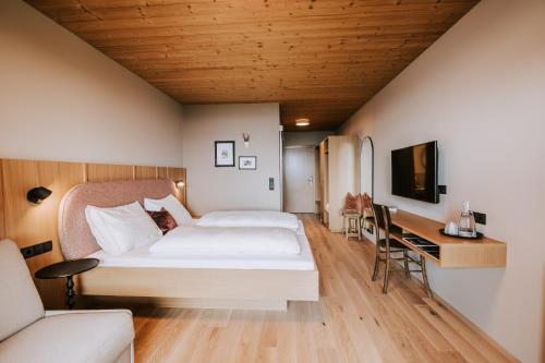 施瓦岑贝格Hotel Marvia的配有一张床和一张书桌的酒店客房